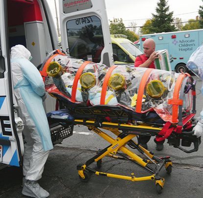 emts wearing ppe loading ambulance