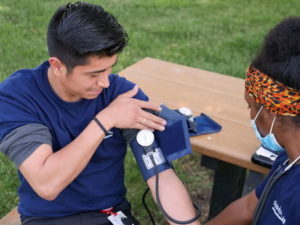 emt student checking blood pressure