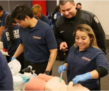 EMT Instructor Watching EMT Students Work on Manikin