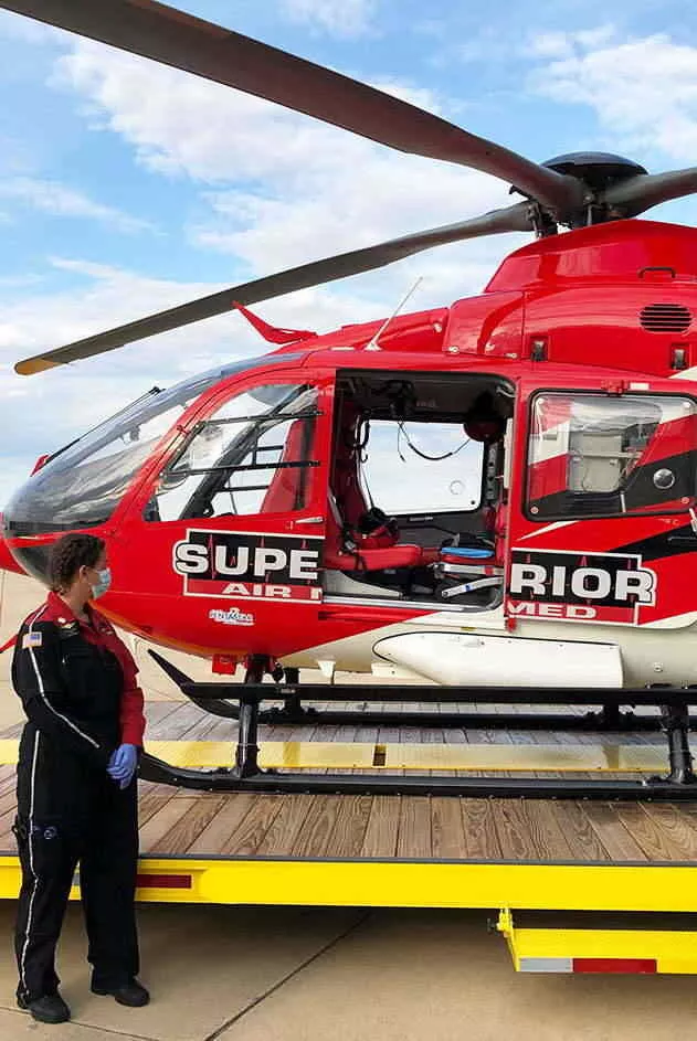 Superior Ambulance Worker Standing Next to Helicopter