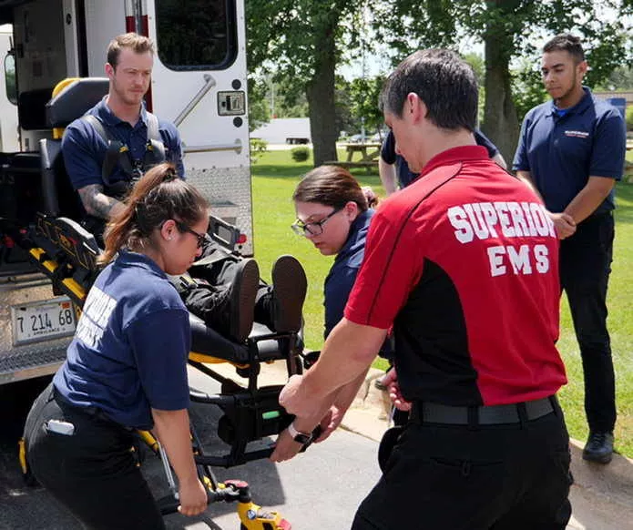 EMS Students Watch Instructor Load Ambulance